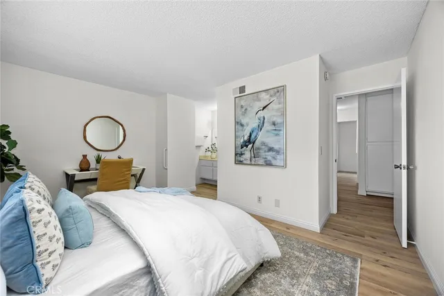 a bedroom with bed and a painting on the wall