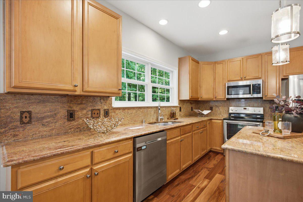 2424 Springbrook Court Huntingtown, MD 20639 - Photo 34 of 103 a kitchen with stainless steel appliances granite countertop a sink a stove and cabinets