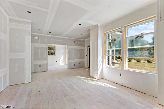 a view of a hallway with wooden floor and a living room
