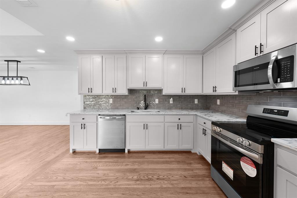104 Mockingbird Street Ector, TX 75439 - Photo 13 of 40 a kitchen with granite countertop cabinets stainless steel appliances and a sink