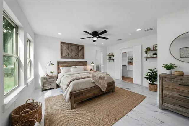 an empty room with wooden floor and ceiling fan