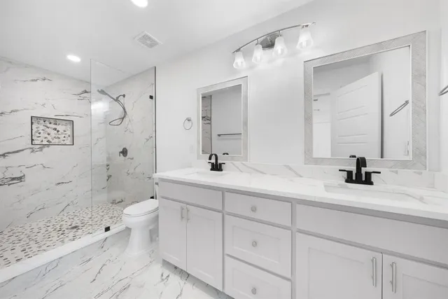 a bathroom with a sink a toilet and shower