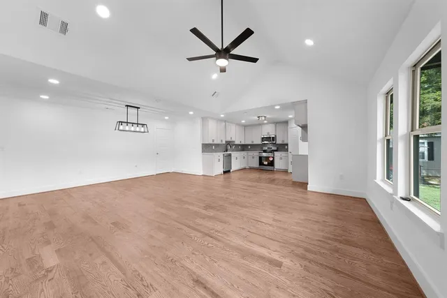 a large kitchen with cabinets wooden floor and stainless steel appliances