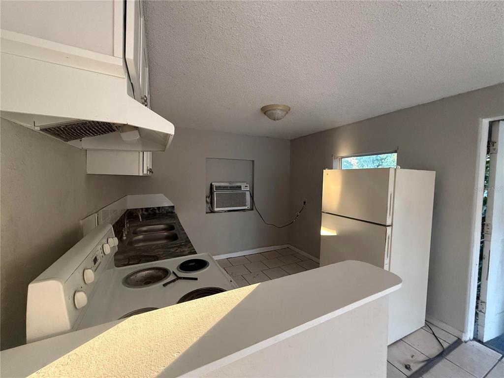 3125 Ave S Northwest, Unit C Winter Haven, FL 33881 - Photo 3 of 7 a kitchen with a refrigerator and a stove