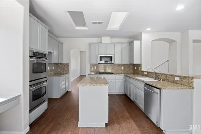 a kitchen with sink stove top oven and microwave