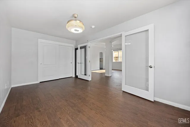 a view of a hallway with wooden floor and a bathroom