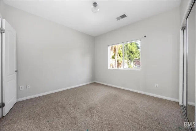 an empty room with windows and closet