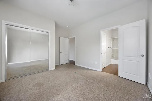an empty room with wooden floor chandelier fan and windows