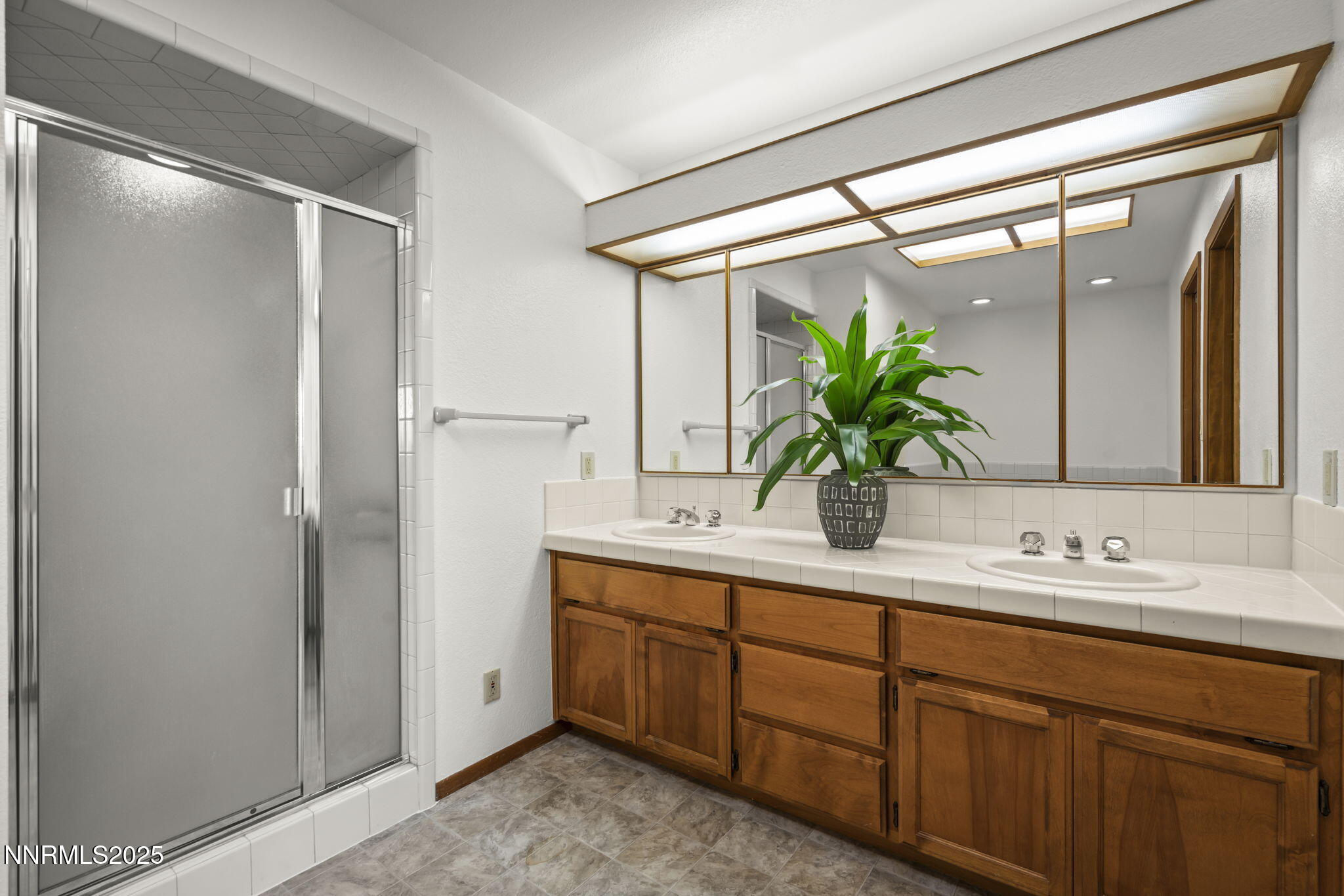 1443 Copper Point Circle Reno, NV 89519 - Photo 16 of 33 a bathroom with a double vanity sink and mirror