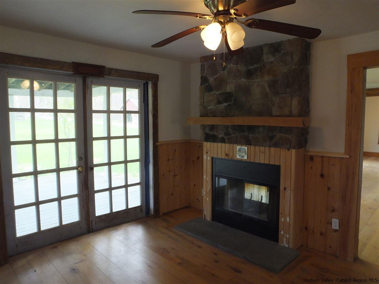 300 Vly Atwood Road Stone Ridge, NY 12484 - Photo 18 of 31 a view of an empty room with wooden floor fireplace and a window