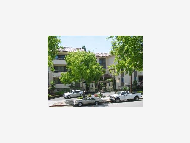 a building outdoor space with couple of cars parked in front of it