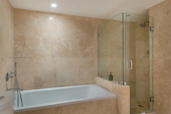 a bathroom with a shower and a bath tub