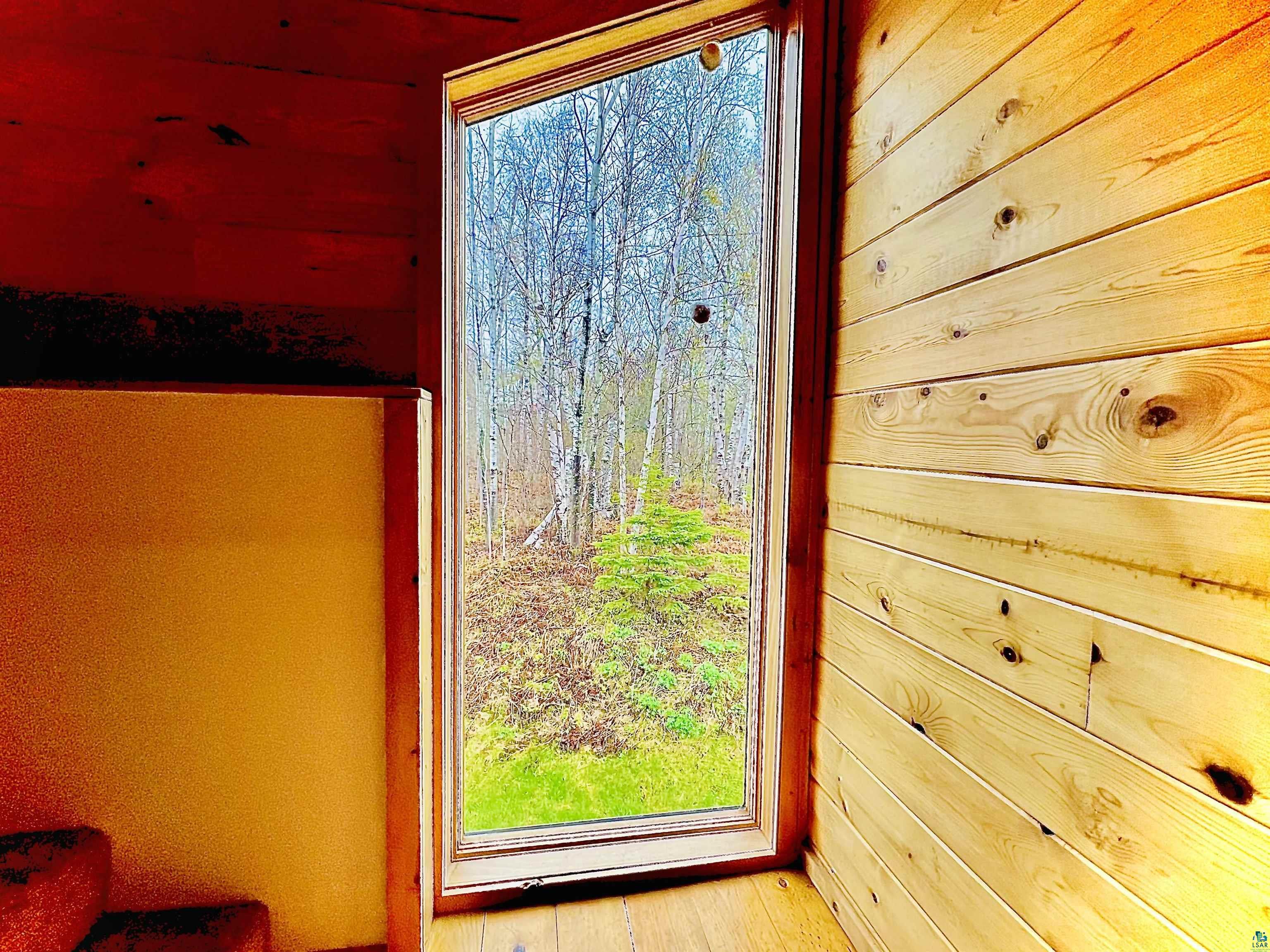 67 Snowshoe Trail Tofte, MN 55615 - Photo 42 of 42 Floor-to-ceiling window overlooking a natural landscape of trees and foliage