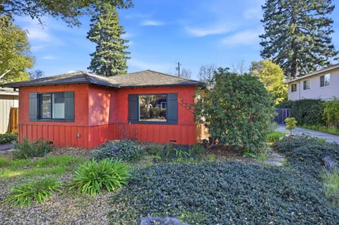 a view of a house with a yard and potted plants
