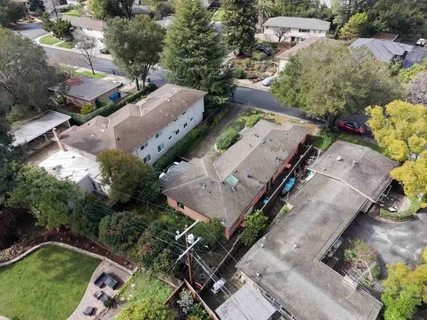 a view of a house with a yard and large trees
