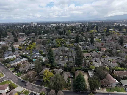a living room with stainless steel appliances furniture and a kitchen