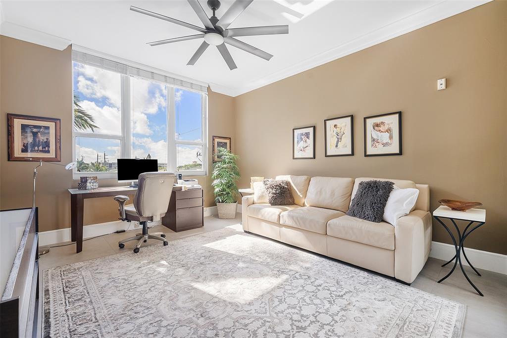 701 Southeast 21st Avenue, Unit 301 Deerfield Beach, FL 33441 - Photo 29 of 63 a living room with furniture a large window and a chandelier
