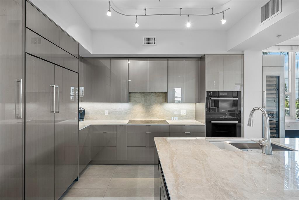 701 Southeast 21st Avenue, Unit 301 Deerfield Beach, FL 33441 - Photo 9 of 63 a large kitchen with kitchen island a sink stainless steel appliances and cabinets