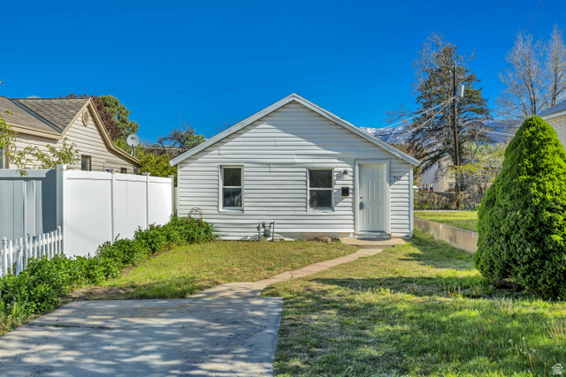 712 9th Street Ogden, UT 84404 - Photo 11 of 15 White siding exterior with a pitched roof, featuring a concrete driveway and walkway