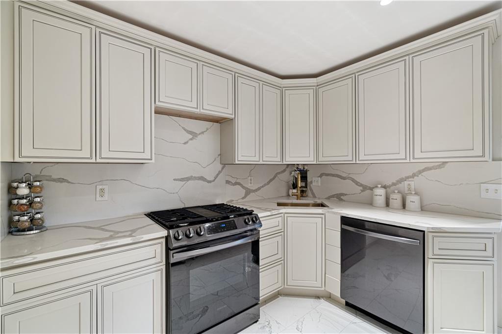5825 Fifth Avenue, Unit 313 Pittsburgh, PA 15232 - Photo 15 of 24 a kitchen with granite countertop white cabinets and white appliances
