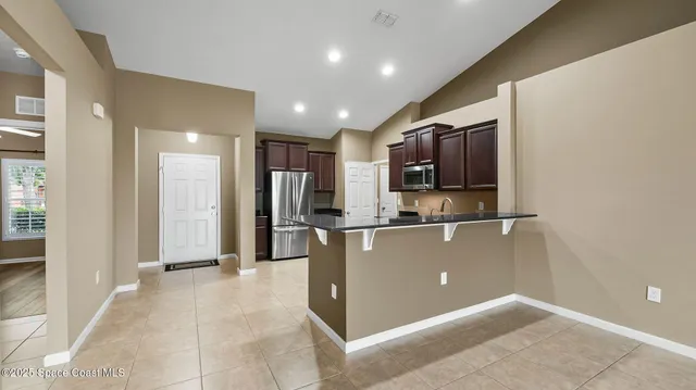 a view of kitchen with refrigerator and windows