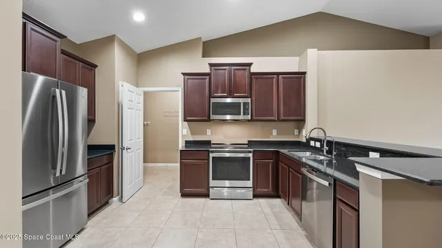 a kitchen with stainless steel appliances granite countertop a refrigerator stove and oven