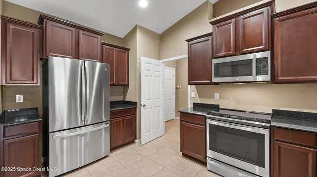 a kitchen with stainless steel appliances and granite counter space