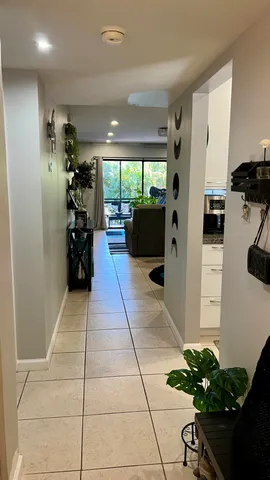 a living room with stainless steel appliances furniture a fireplace and a potted plant