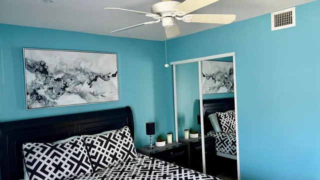 a bedroom with a bed and a painting on the wall