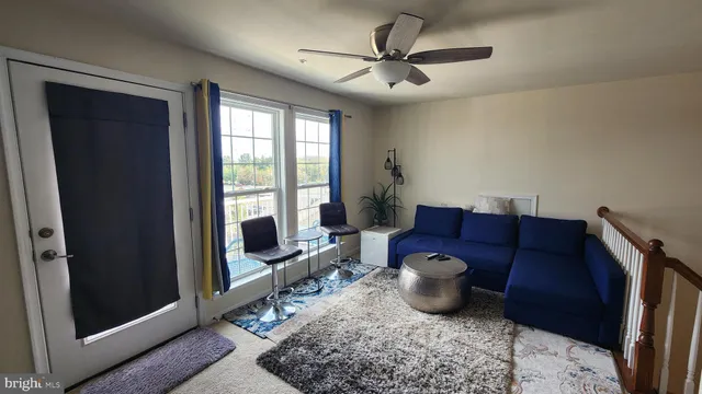 a living room with furniture a flat screen tv and a window
