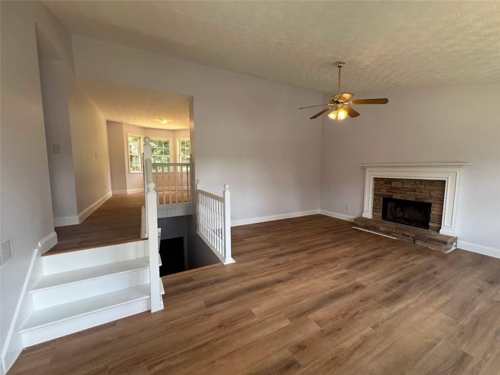 89 Farm Brook Lane Dallas, GA 30157 - Photo 2 of 42 an empty room with wooden floor fireplace and chandelier