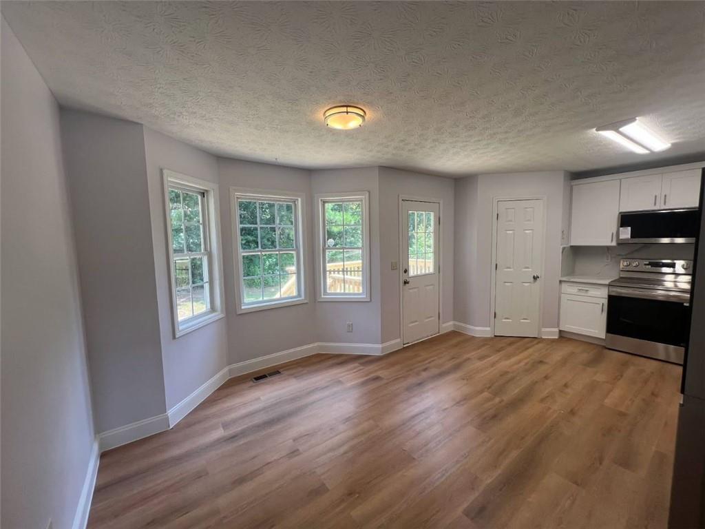 89 Farm Brook Lane Dallas, GA 30157 - Photo 5 of 42 a view of an empty room with a window and wooden floor