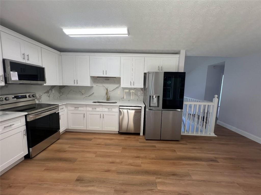 89 Farm Brook Lane Dallas, GA 30157 - Photo 7 of 42 a kitchen with granite countertop white cabinets and stainless steel appliances