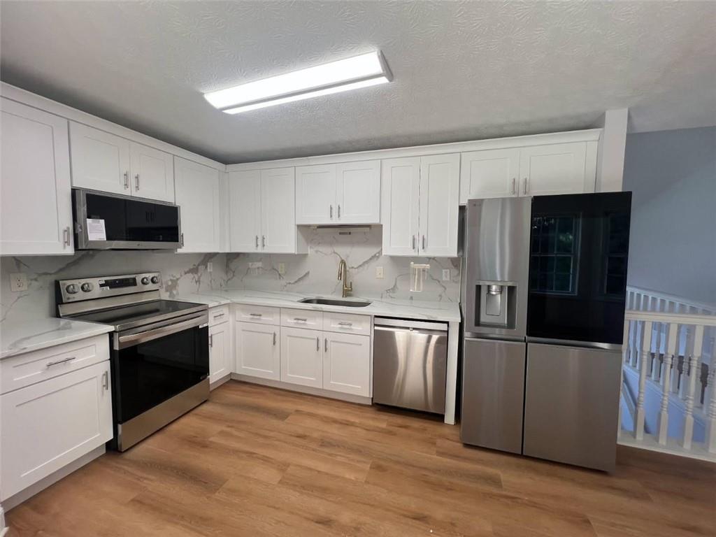 89 Farm Brook Lane Dallas, GA 30157 - Photo 8 of 42 a kitchen with granite countertop a refrigerator stove and sink
