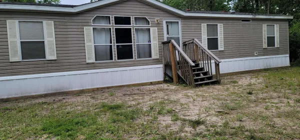 a view of a house with a window and wooden fence
