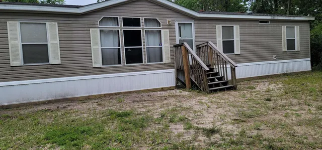 a view of a house with a window and wooden fence