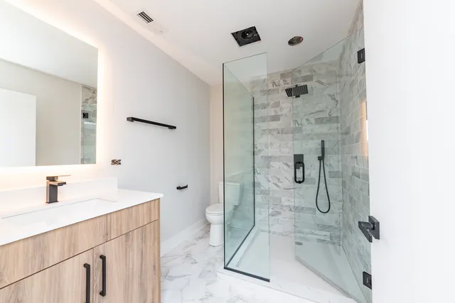 a bathroom with a shower sink and mirror