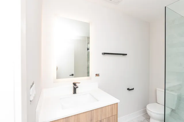 a bathroom with a sink a toilet and shower