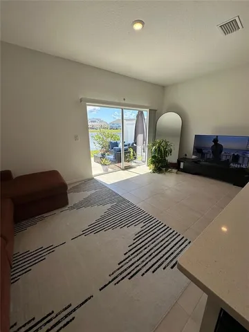 a view of patio with couches table and chairs under an umbrella with wooden floor