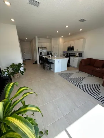 a bedroom with a bed and a flat tv screen on dresser