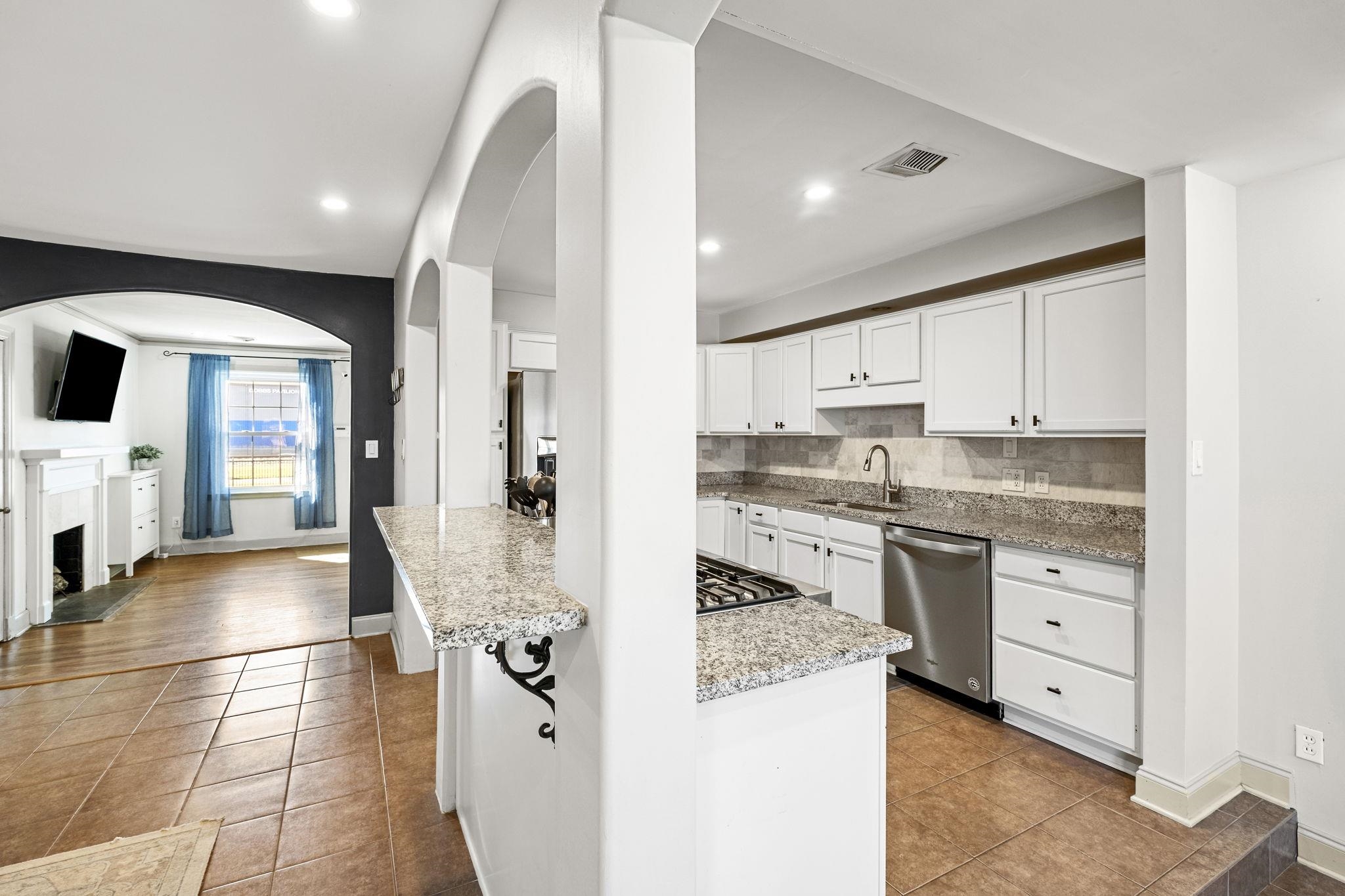 4120 Village Road Memphis, TN 38117 - Photo 9 of 28 Kitchen with white cabinets, light stone counters, dishwasher, light tile patterned flooring, and recessed lighting