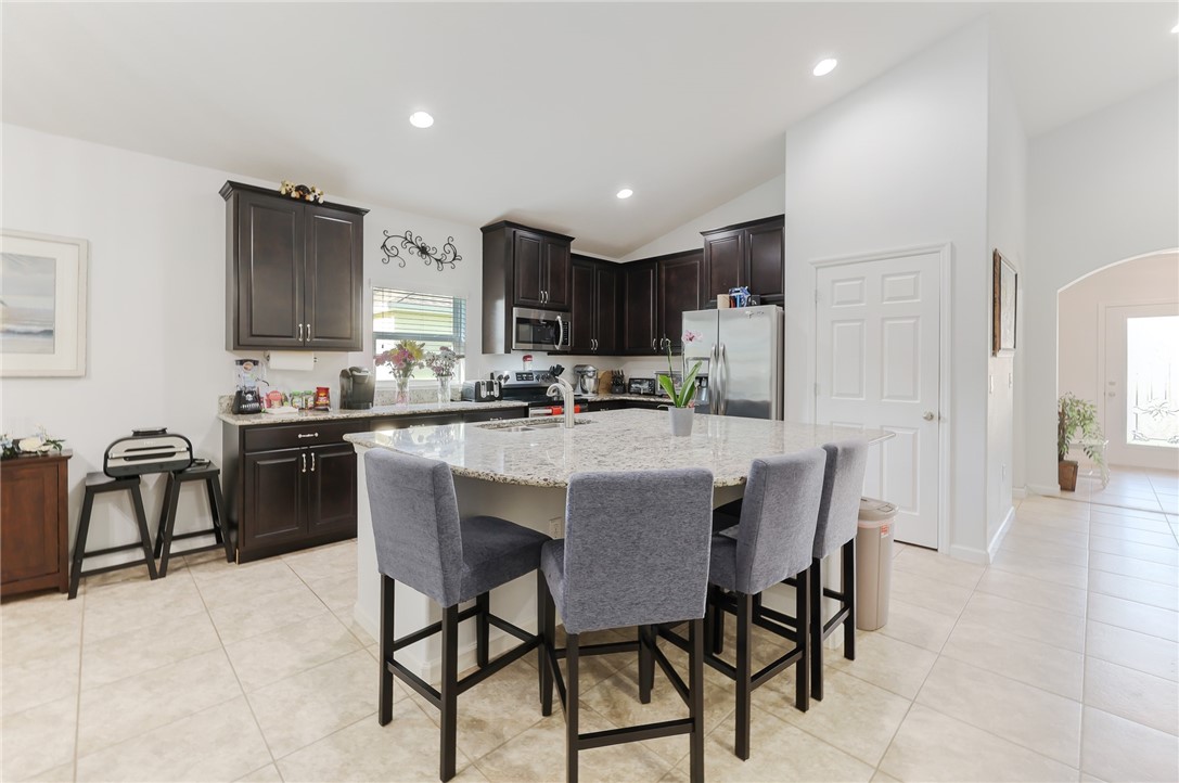 5997 Ridge Lake Circle Vero Beach, FL 32967 - Photo 11 of 36 a kitchen with a dining table chairs and refrigerator