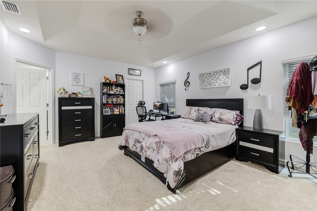 5997 Ridge Lake Circle Vero Beach, FL 32967 - Photo 18 of 36 a spacious bedroom with a bed and a television