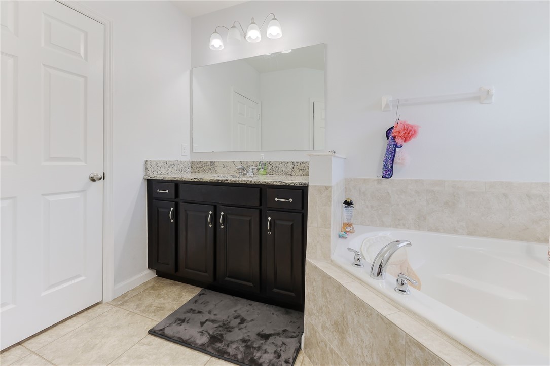 5997 Ridge Lake Circle Vero Beach, FL 32967 - Photo 20 of 36 a spacious bathroom with a tub sink and mirror