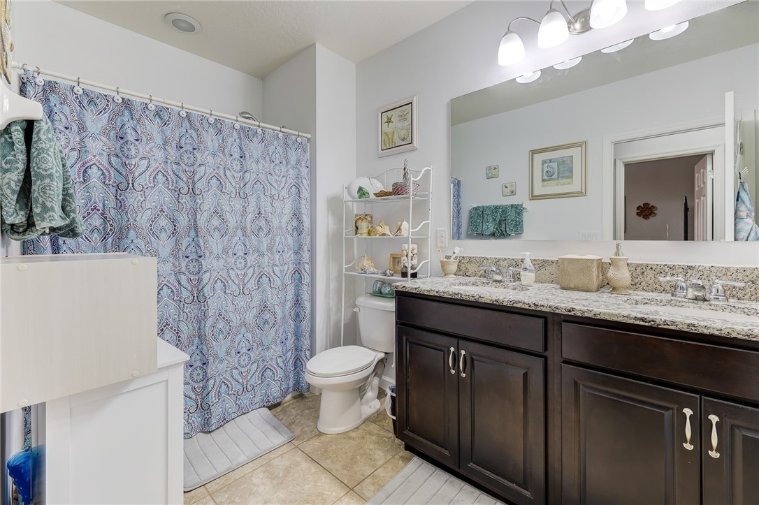 5997 Ridge Lake Circle Vero Beach, FL 32967 - Photo 24 of 36 a bathroom with a granite countertop toilet sink and mirror