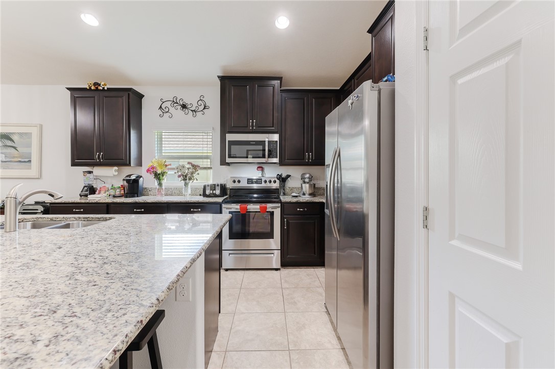 5997 Ridge Lake Circle Vero Beach, FL 32967 - Photo 7 of 36 a kitchen with stainless steel appliances granite countertop a refrigerator a stove and a sink