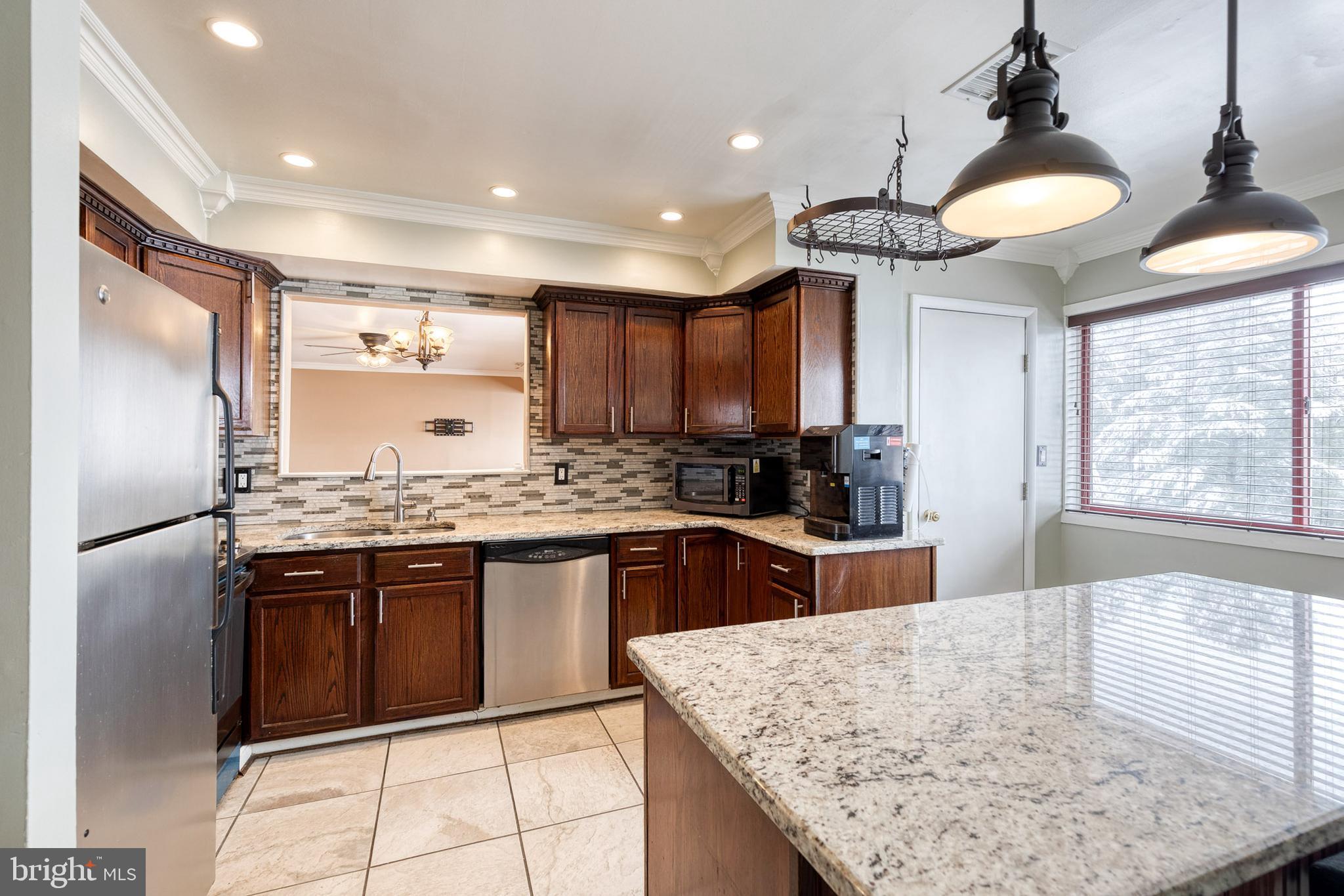 8008 Valley Manor Road, Unit 3B Owings Mills, MD 21117 - Photo 1 of 19 a kitchen with stainless steel appliances granite countertop a sink stove and refrigerator