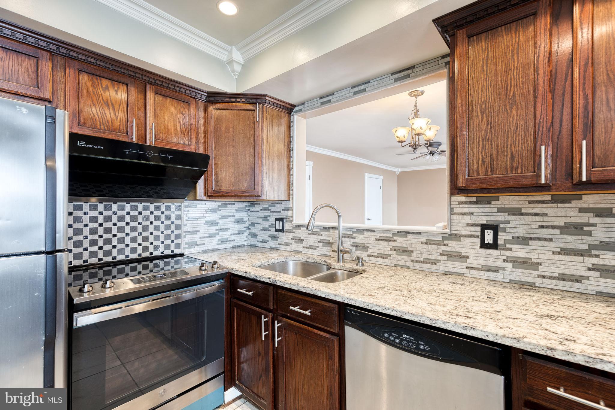 8008 Valley Manor Road, Unit 3B Owings Mills, MD 21117 - Photo 10 of 19 a kitchen with granite countertop a sink stove and cabinets