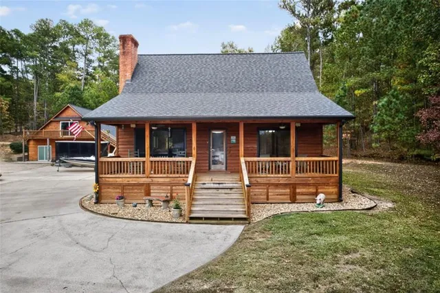 a view of a house with backyard and trees in the background