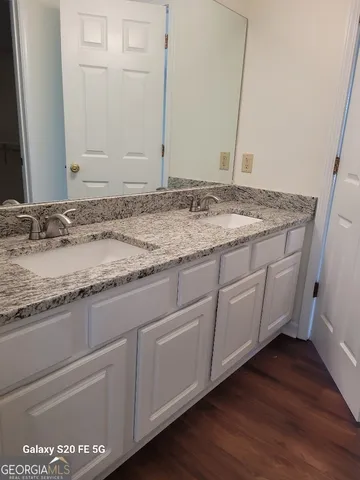 a bathroom with a granite countertop sink and a mirror